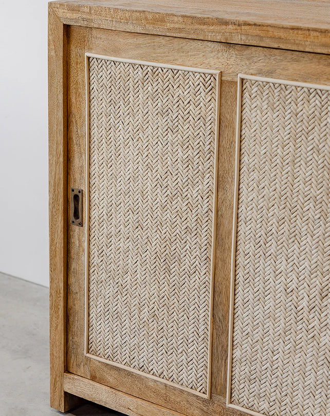 Wooden cabinet with woven design on doors against a white wall