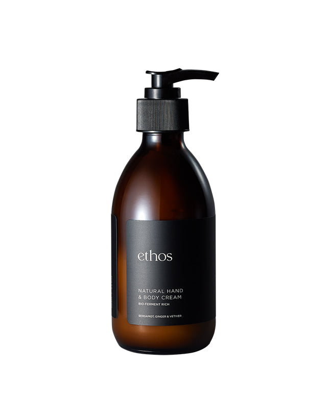 Brown bottle of ethos hand and body cream on a white background