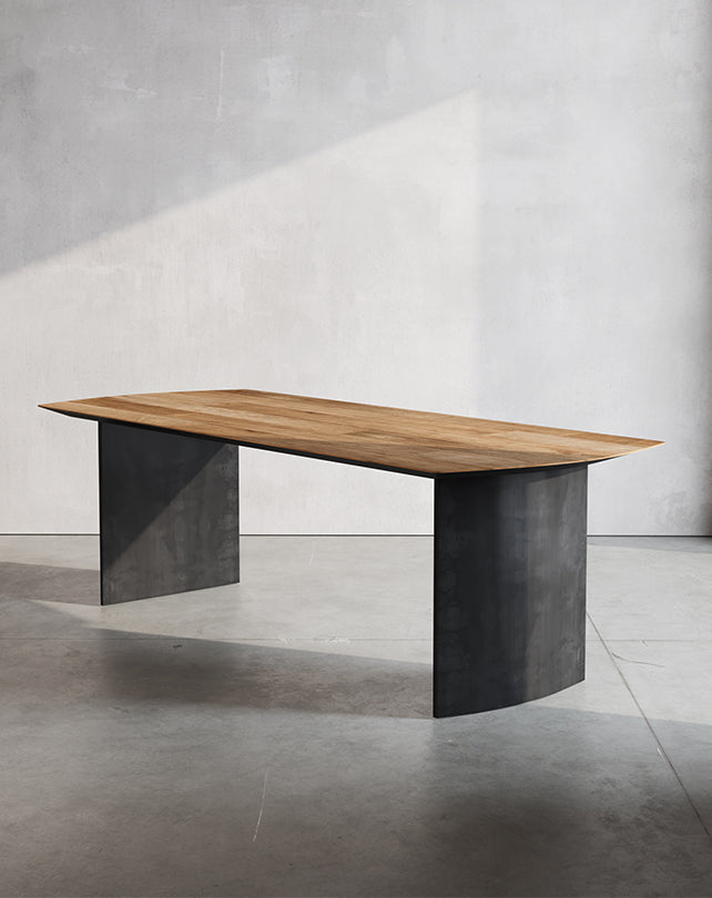 Modern dining table with black metal and wood design in a well-lit room.