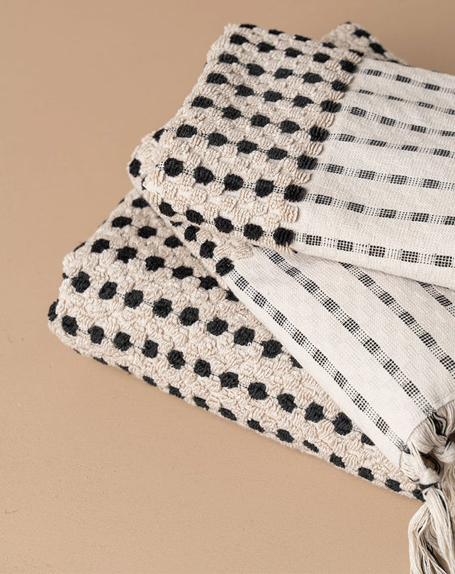 Folded fabric with black and white pattern on a beige background