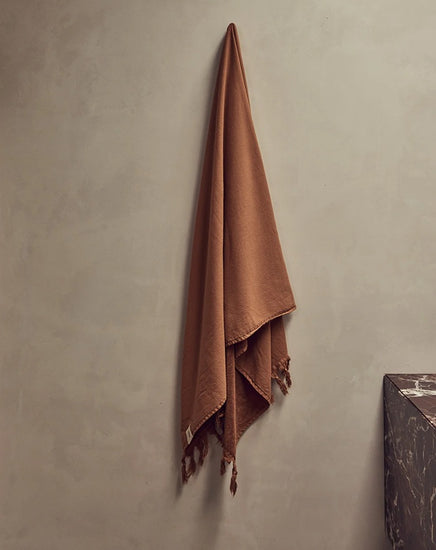 Brown towel hanging on a gray wall