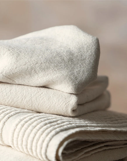 Stack of folded beige towels on a soft beige background